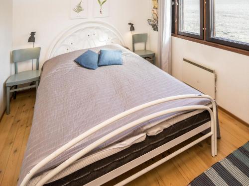 a large bed with two blue pillows on it at Holiday Home Pikku-puntila by Interhome in Niemikylät