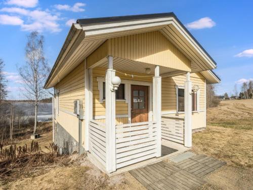 a tiny house with a porch on a field at Holiday Home Pikku-puntila by Interhome in Niemikylät