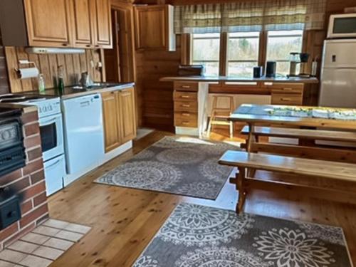 a kitchen with white appliances and wooden cabinets at Holiday Home Rantatalo by Interhome in Hirsjärvi