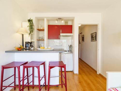 a kitchen with red stools and a counter top at Studio Bellevue Clemenceau-2 by Interhome in Biarritz