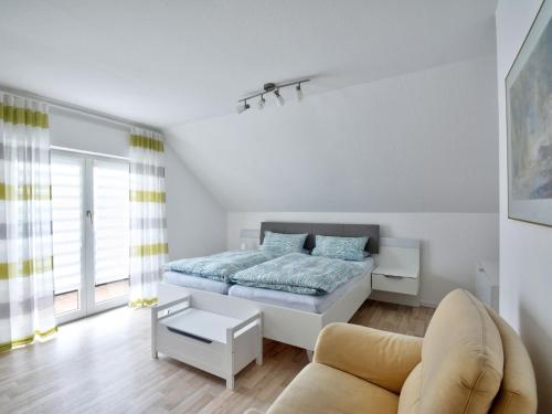 a white bedroom with a bed and a couch at Apartment Waldvogt by Interhome in Lothe