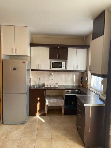 a kitchen with white cabinets and a stainless steel refrigerator at Calm island near the Danube - free parking in Budapest