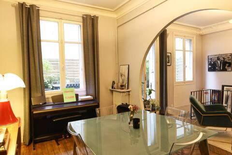 - un salon avec une table en verre et une chaise dans l'établissement Rare à Paris, magnifique souplex familial, 3 chambres doubles, grande terrasse, très frais en été, à Paris
