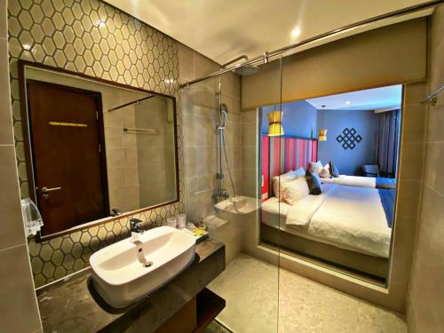 a bathroom with a sink and a bed and a mirror at APEC MANDALA CHAMBAY MŨI NÉ in Ấp Thiẹn Ái