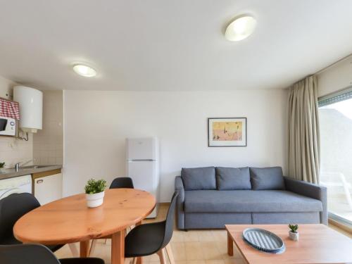 een woonkamer met een blauwe bank en een tafel bij Apartment Mismar-4 by Interhome in Roses