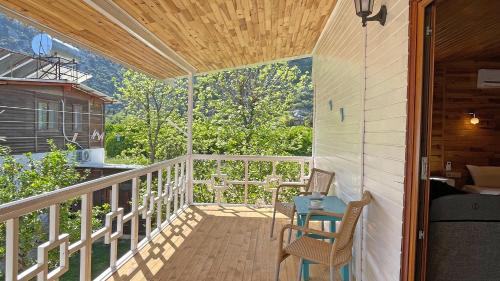 a porch with two chairs and a table on it at Jasmin Pansiyon Çıralı in Cıralı
