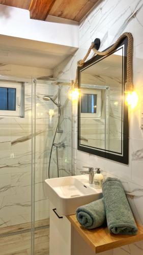 a bathroom with a sink and a mirror at Stara Piekarnia Tolkmicko in Tolkmicko