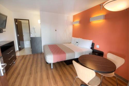 a hotel room with a bed and a table at Motel 6-Lethbridge, AB in Lethbridge