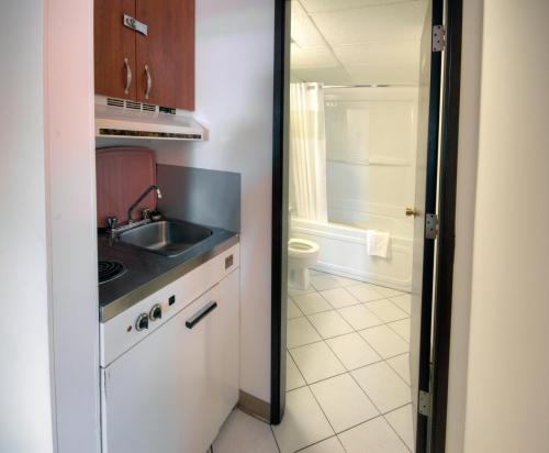 a small kitchen with a sink and a stove at Motel 6-Lethbridge, AB in Lethbridge
