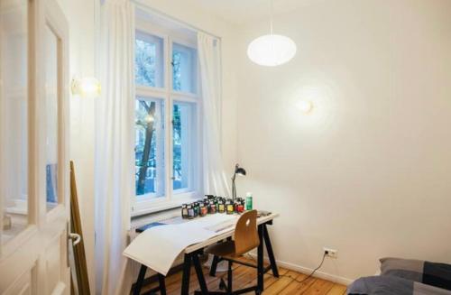 Cette chambre dispose d'une table avec des chaises et d'une fenêtre. dans l'établissement cosy apartment in friedrichshaun, à Berlin