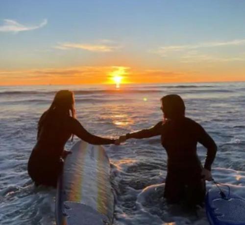 two people in the water with surfboards in the ocean at Sunny Delight I in Cape Canaveral