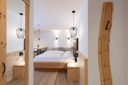 フォルテッツァにあるZur Brücke apartments and rooms - Your home in heart of South Tyrol, with Brixencardのベッドとテーブルのある寝室