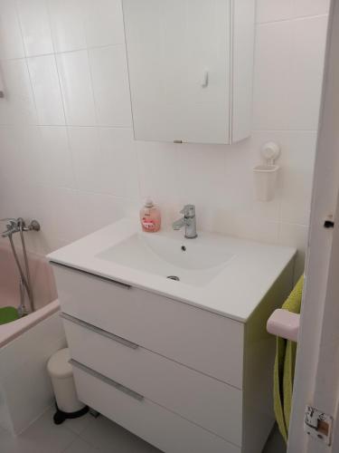 a white bathroom with a sink and a tub at Helle moderne Ferienwohnung 500m v.Meer in Almería