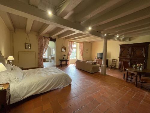 - une chambre avec un lit et un salon dans l'établissement Château du Montellier, à Le Montellier
