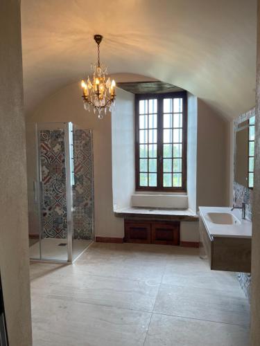Elle comprend une grande salle de bains pourvue d'un lavabo et d'un lustre. dans l'établissement Château du Montellier, à Le Montellier