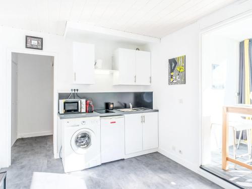 a kitchen with a washing machine and a microwave at Studio Port Arcachon-2 by Interhome in Arcachon