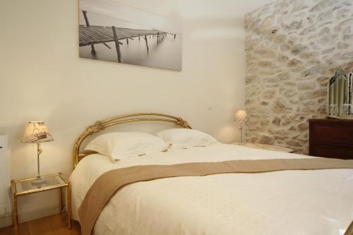 une chambre avec un lit avec un tableau sur le mur dans l'établissement L'Estaou de Julie- Meublé de Tourisme 4 Étoiles, à Saint-Paul-et-Valmalle