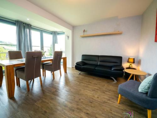 sala de estar con sofá negro y mesa en Apartment Am Kirchberg by Interhome en Lügde