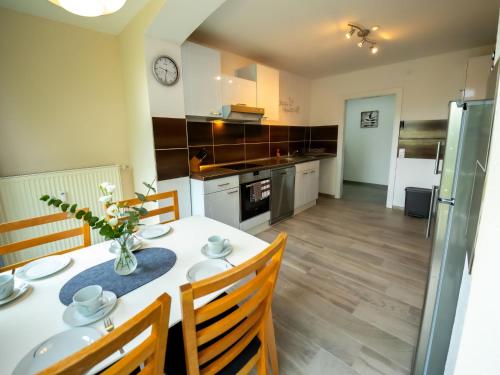 een keuken met een tafel en stoelen en een keuken met een klok bij Apartment Am Kirchberg by Interhome in Lügde