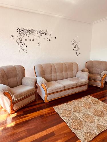 a living room with two couches and butterflies on the wall at MartinVidal 3 in Luarca