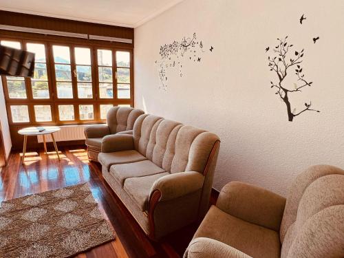 a living room with a couch and birds on the wall at MartinVidal 3 in Luarca