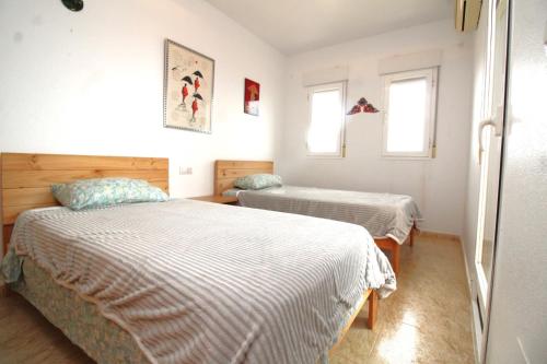 - une chambre avec 2 lits et 2 fenêtres dans l'établissement Sea view holiday home sleeps 10, à Murcie