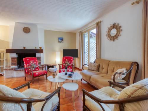 - un salon avec un canapé, des chaises et une cheminée dans l'établissement Holiday Home Les Sylvaines by Interhome, à Carcans