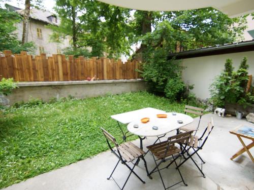 un patio avec une table et des chaises dans une cour dans l'établissement Apartment Les Jardins de l'Astoria by Interhome, à Chamonix-Mont-Blanc
