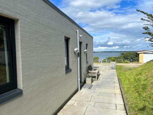 - un bâtiment avec une passerelle à côté de l'océan dans l'établissement Holiday Home Laila - 5m from the sea in Funen by Interhome, à Middelfart