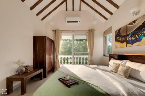 a bedroom with a large bed and a window at Ra-3Bed Villa W/PVTpool in Assagao by Masaya Stays in Verla