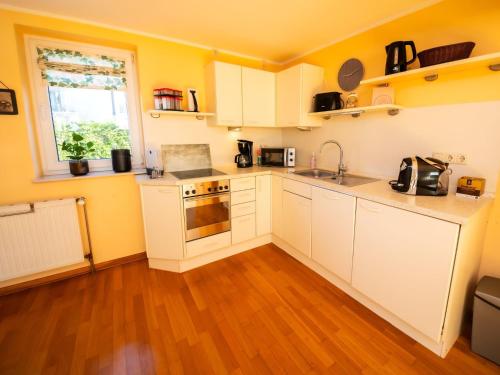 een keuken met witte kasten en een houten vloer bij Holiday Home Mia by Interhome in Lügde