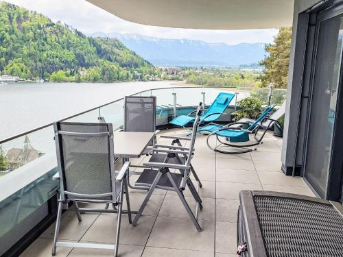 d'un balcon avec des chaises et une table offrant une vue sur l'eau. dans l'établissement Apartment Adlerblick alpe maritima Ski & See - 22 by Interhome, à Annenheim