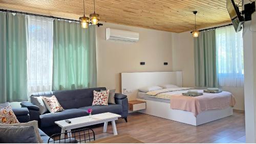 a living room with a bed and a couch at Jasmin Pansiyon Çıralı in Cıralı