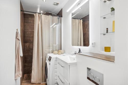 a white bathroom with a sink and a shower at Come Stay - 2BR Det perfekte hjem for 5 in Aalborg