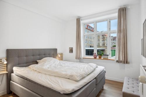 Schlafzimmer mit einem Bett und einem Fenster in der Unterkunft Come Stay - 2BR Det perfekte hjem for 5 in Aalborg