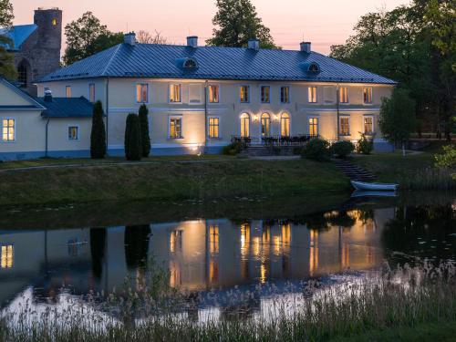a large white house with a pond in front of it at Padise Manor in Padise