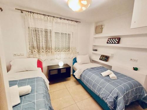 a bedroom with two beds and a window at Varkiza Seaside 2BD Apartment in Varkiza