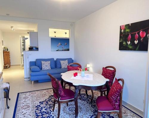 uma sala de estar com uma mesa e cadeiras e um sofá azul em Ferienwohnung Casa del Vino em Neustadt an der Weinstraße