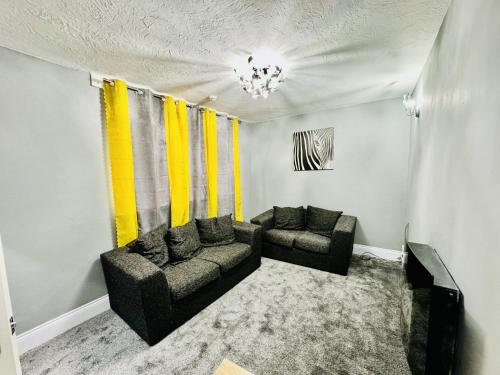 a living room with two couches and yellow curtains at 4-Bed Full House Stourbridge Birmingham in Stourbridge