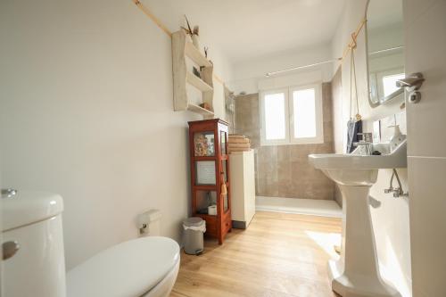 a bathroom with a white toilet and a sink at Maria La Franca in La Franca