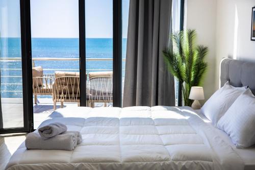 um quarto com uma cama branca e vista para o oceano em Costa Del Sol em Durrës