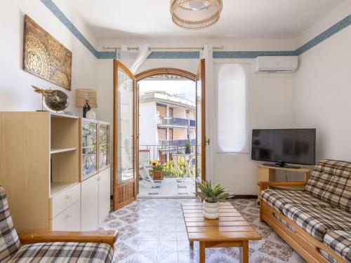 sala de estar con sofá y TV en Apartment Atena by Interhome, en Giardini Naxos