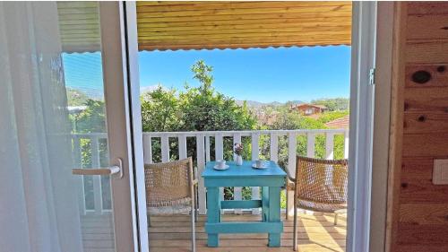 a table on a balcony with a view of the ocean at Jasmin Pansiyon Çıralı in Cıralı