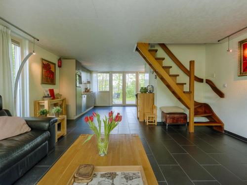 een woonkamer met een trap en een vaas met bloemen bij Holiday Home De Smokkelaar by Interhome in Simpelveld