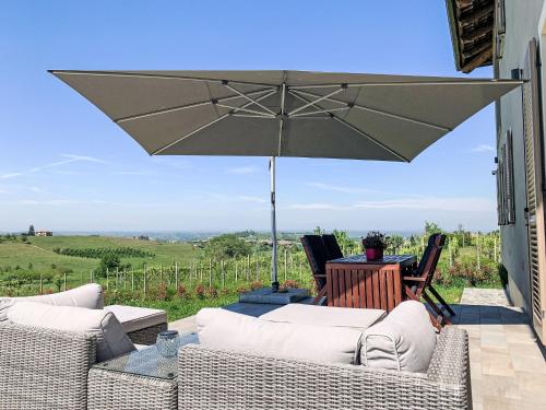 a patio with two couches and an umbrella at Apartment Oleandro by Interhome in Costigliole dʼAsti