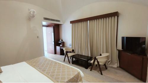 a hotel room with a bed and a desk and a television at Ayodhya haat Luxury Cottages in Ayodhya