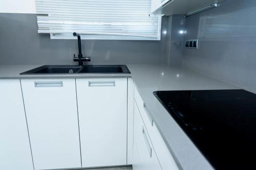 a white kitchen with a sink and a window at Alojamiento La Caseta de Nando in Tortosa