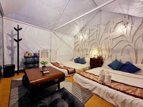 een kamer met 2 bedden en een bureau in een tent bij ไร่ภูพญา ม่อนแจ่ม เชียงใหม่ in Mon Jam
