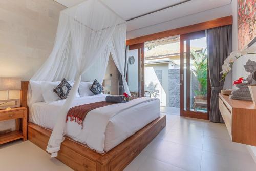 un dormitorio con una cama con mosquitera en Royal Cottage Private Villa, en Ubud