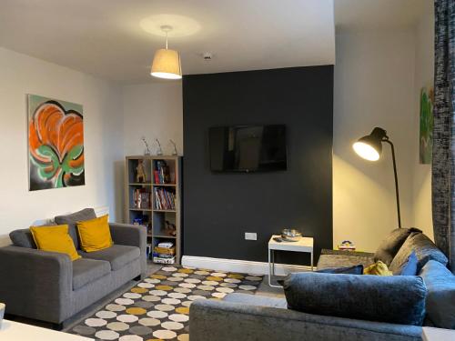a living room with two couches and a tv at Mia's Place Three Apartments in One in Chester